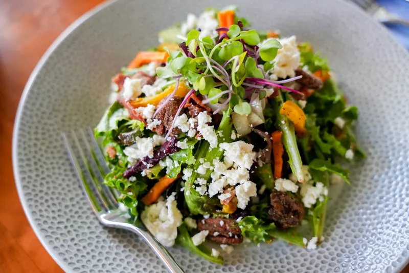 A salad of greens topped with crumbled cheese