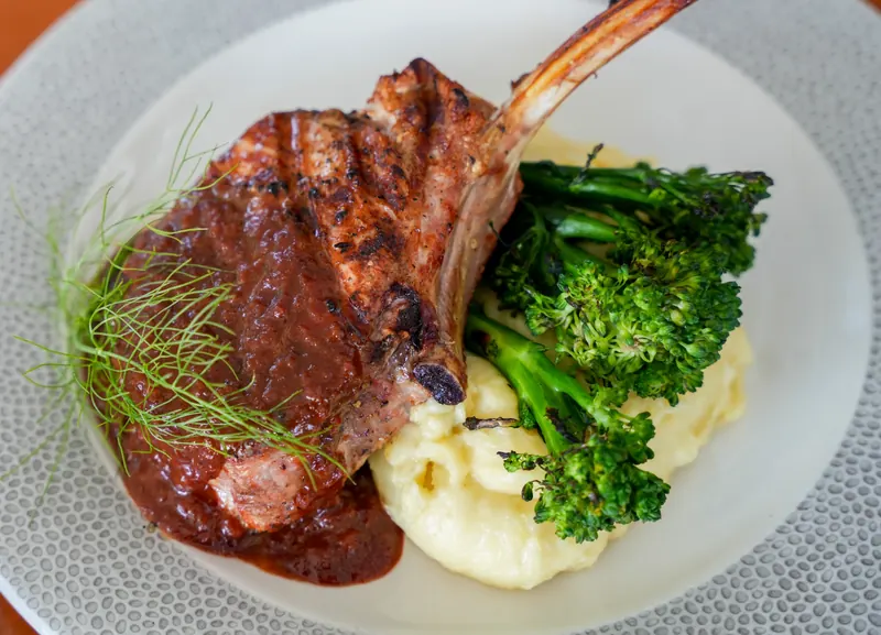 A bone in chop with broccolini and mashed potato